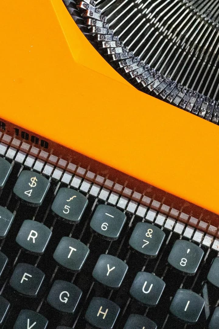 Typebars fanned out behind the orange body, above the number row